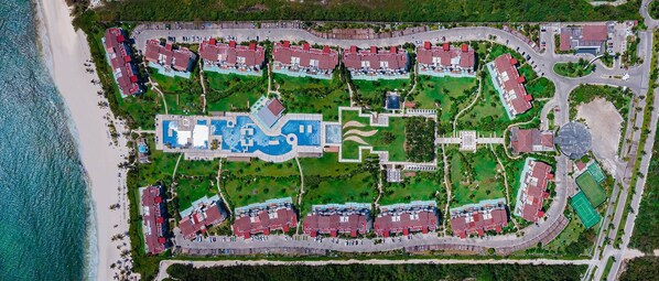 An aerial view of a resort with multiple buildings, a large central pool, and a beach. - Mareazul (Playa del Carmen)