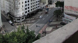 Stadsbeeld met hoge gebouwen, een straat met auto's en voetgangers.