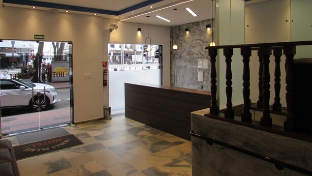 Een hotel receptie met een incheckbalie, een receptieplein en uitzicht op de straat.