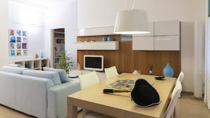 Un salon moderne avec un canapé, une table à manger et un téléviseur.