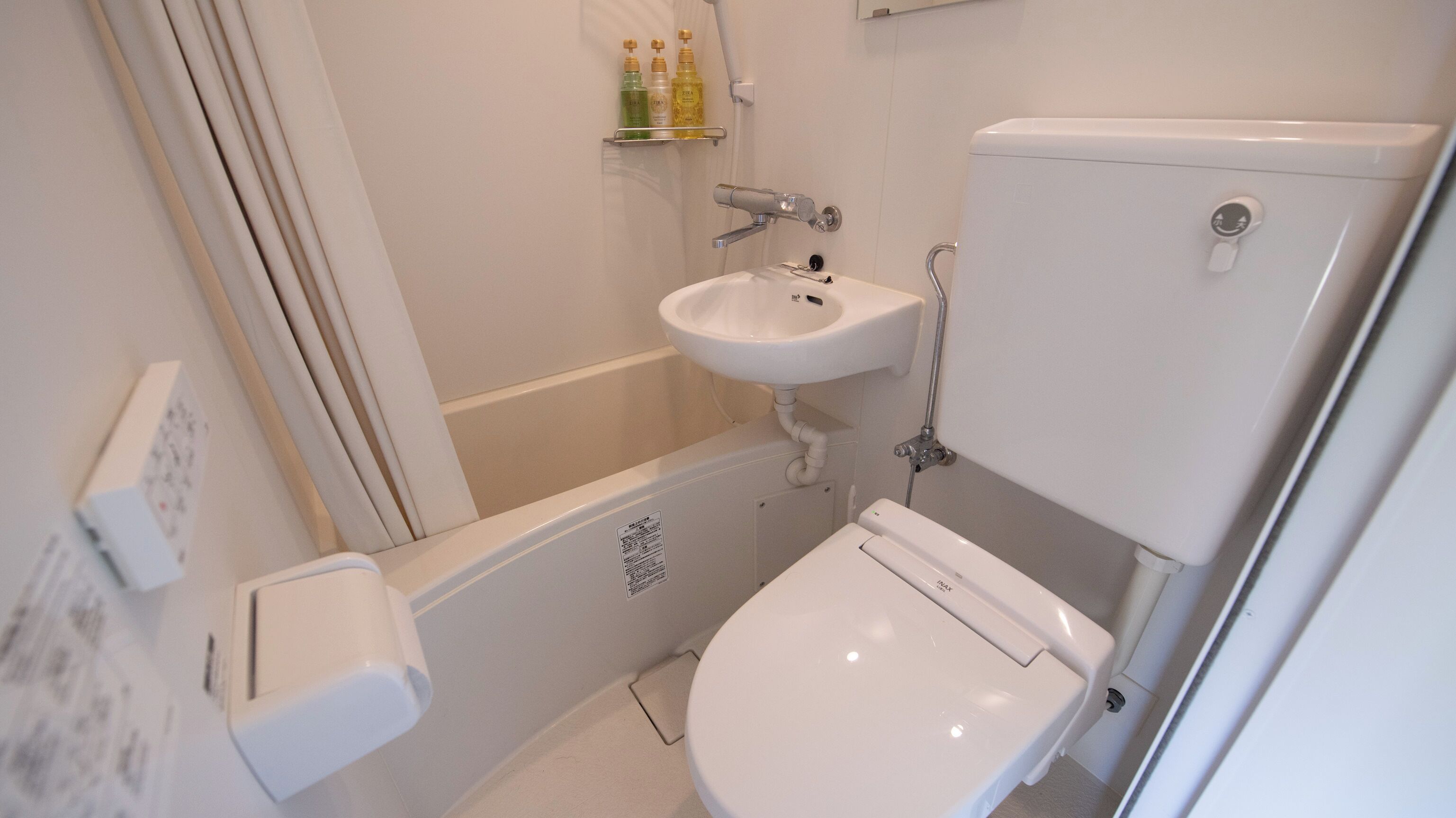 Un bagno con il water, lavabo e doccia.