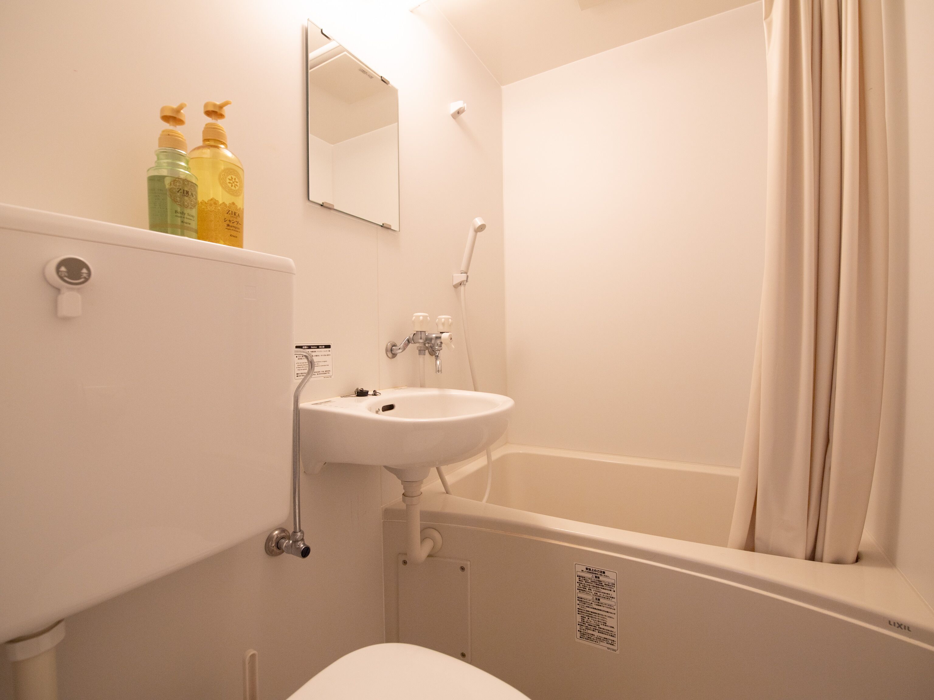 Une salle de bain avec un lavabo, un miroir et une baignoire.