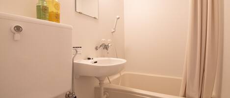 Une salle de bain avec un lavabo, un miroir et une baignoire.