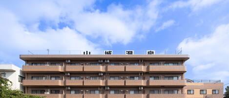 Un edificio de varios pisos con techo plano y un letrero sobre la entrada.