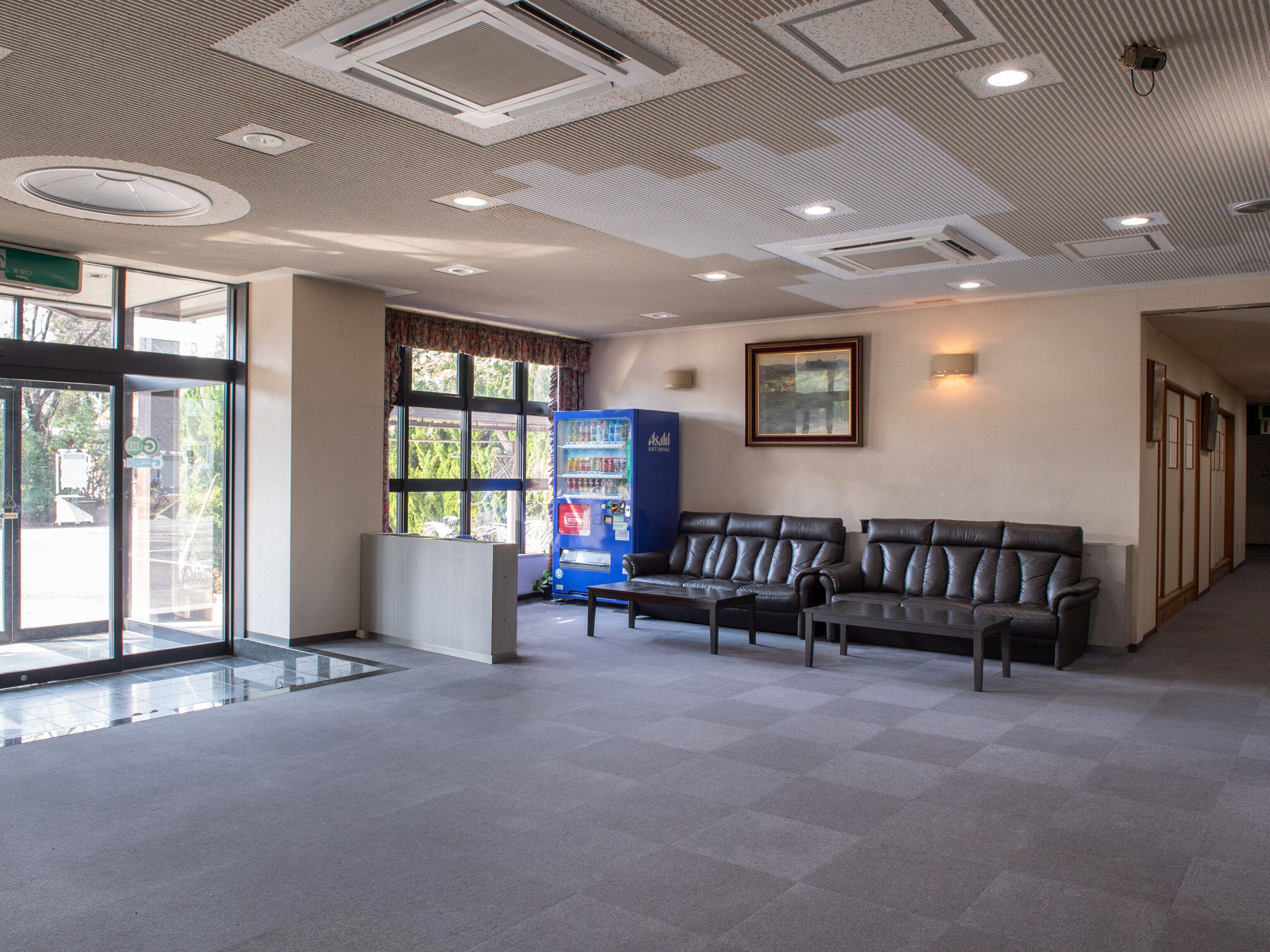 A reception area with a seating area, a vending machine, and a framed picture on the wall.
