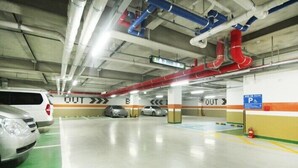 An underground parking garage with multiple levels, marked exit signs, and a fire extinguisher. - Time Square Hotel (Yangsan)