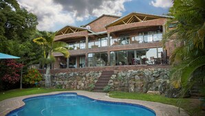 Un bâtiment à deux étages avec une piscine devant.
