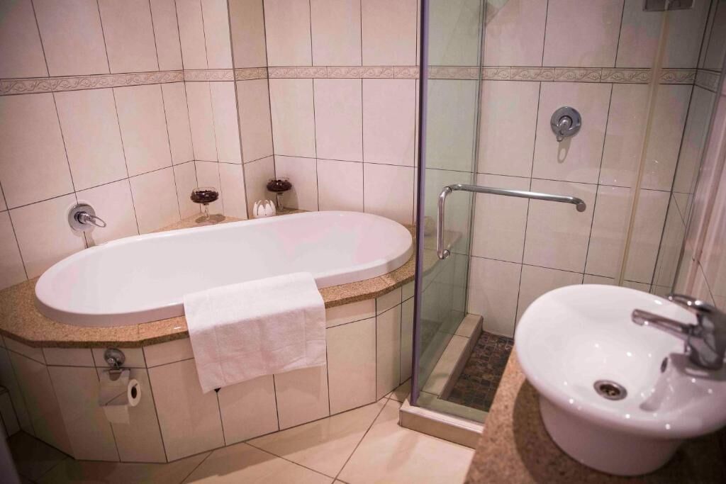 A bathroom with a freestanding bathtub, a glass-enclosed shower, and a pedestal sink.