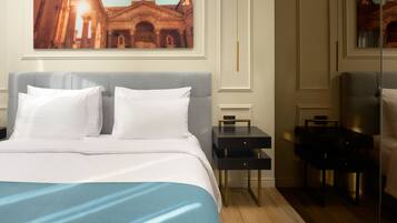 Una habitación de hotel con una cama grande, una mesita de noche, un escritorio y una silla.