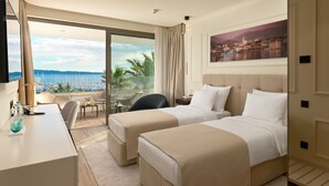 A hotel room with two beds, a desk, a chair, and a large window with a view of the sea. - Mirari Boutique Hotel (Split)