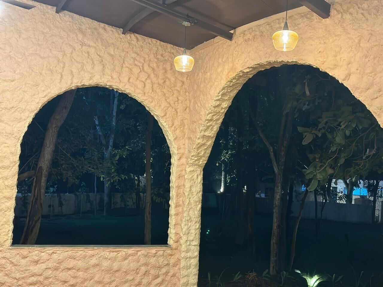 A rustic building with arched windows and a textured wall.