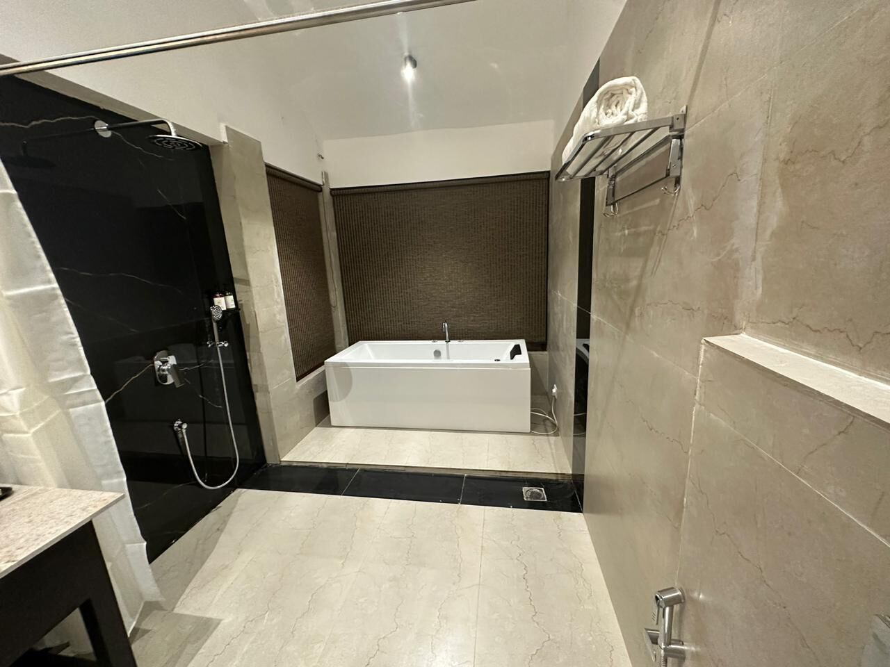 Un bagno moderno con una vasca autonoma, una cabina doccia in vetro e un pavimento in marmo.