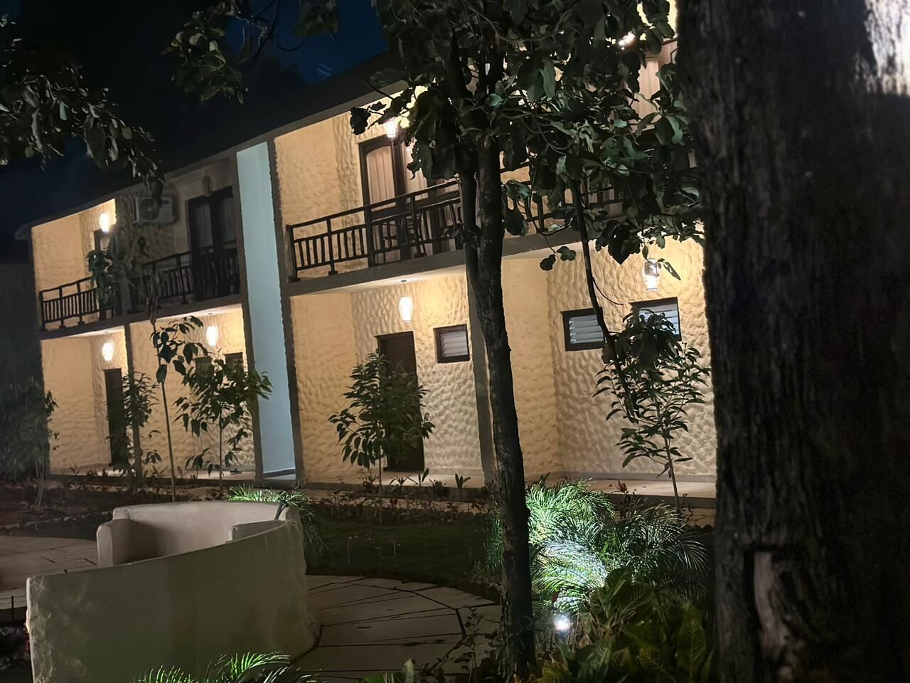 Een gebouw met balkon en zwembad bij nacht.