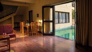 Un vaste espace de vie doté d’un plancher en bois, d’une table à manger avec des chaises, d’un canapé et d’un escalier.