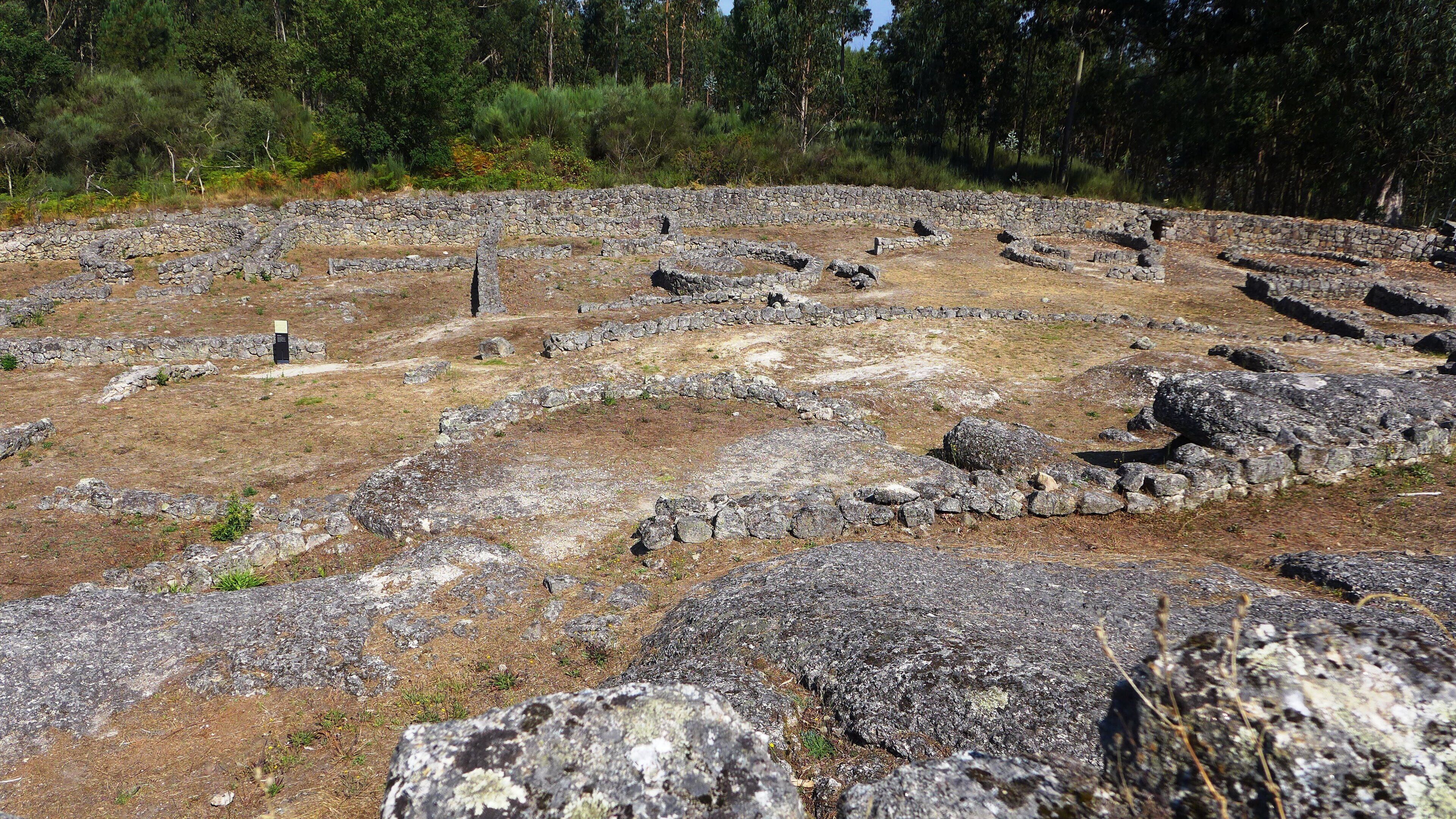 En arkeologisk plats med stenruiner och en cirkelformad planlösning.