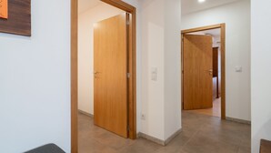 A hallway with wooden doors and a tiled floor. - Casas da Petisqueira 61 - Paredes-Oporto (Paredes)