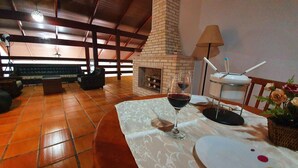 Ein gemütliches Wohnzimmer mit Kamin, Tisch mit einem Weinglas und einer bequemen Sitzecke.