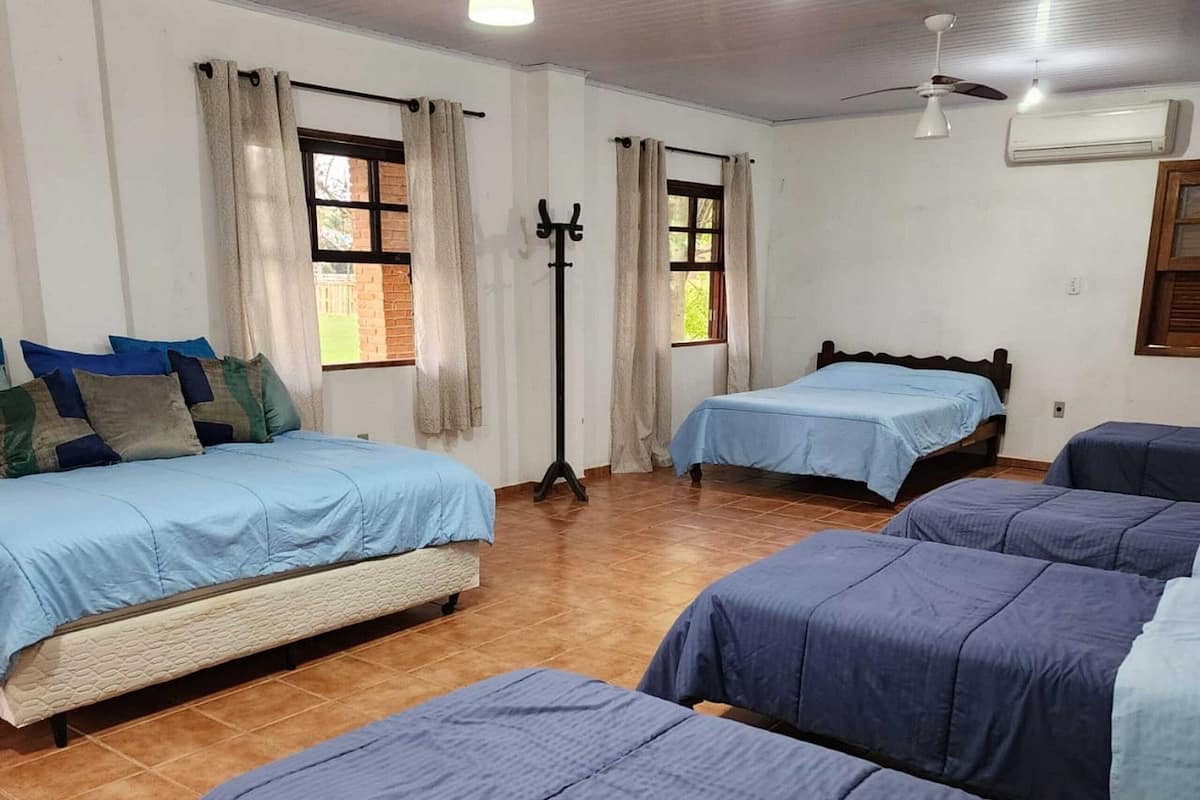 Una habitació amb dos llits, una làmpada de peu i un aparell d'aire condicionat.