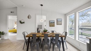 A dining area with a wooden table and six chairs, a potted plant, and artwork on the walls. - Starlight Horizon (Canyon Lake)