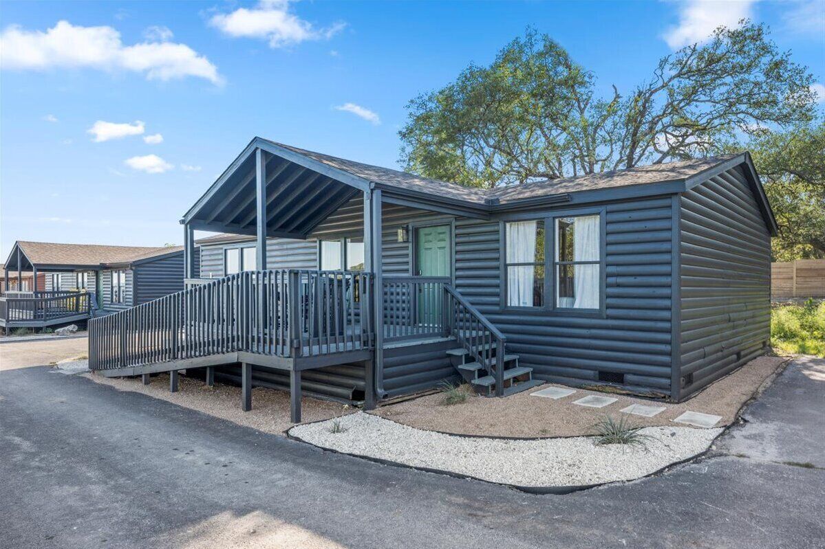 A single-story cabin with a covered porch and a small deck.