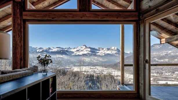 Ein Zimmer mit großem Fenster und Blick auf die Berge.