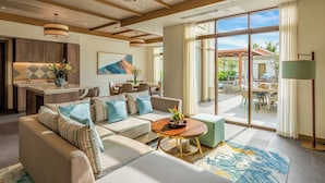 A spacious living room with a large sofa, a coffee table, and a dining area with a table and chairs. - Fusion Resort & Villas Da Nang (Da Nang)