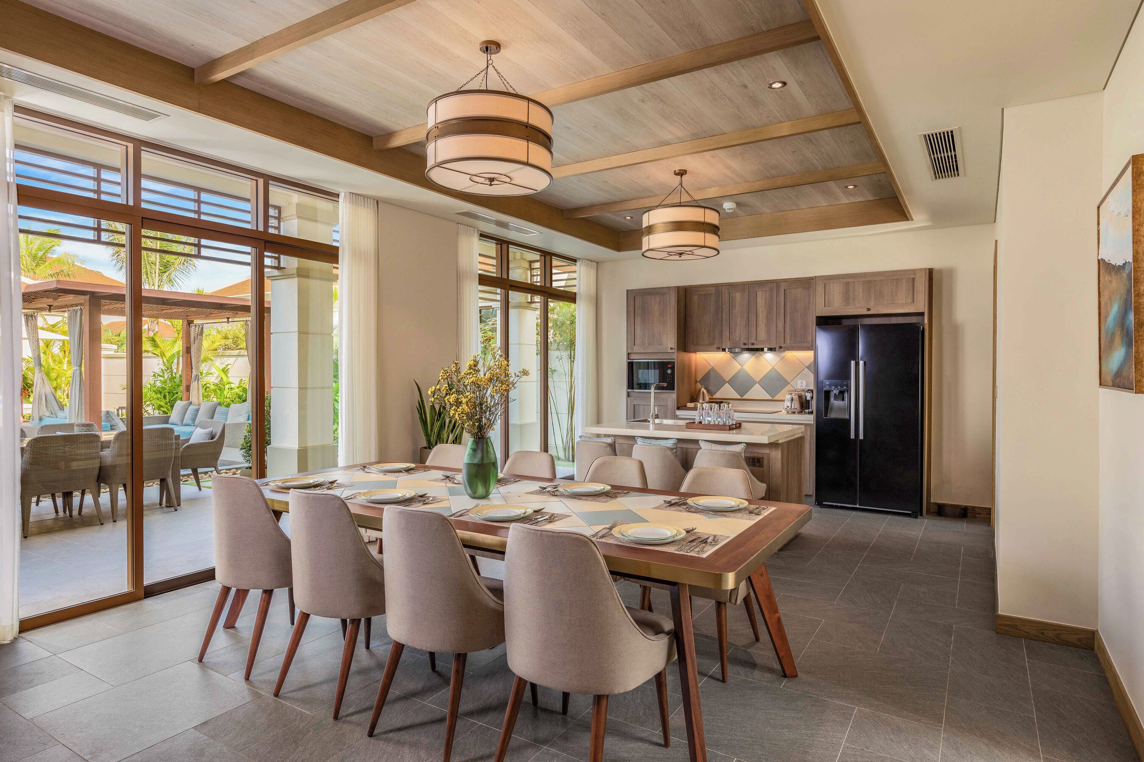 A spacious dining area with a large table set for six, surrounded by modern chairs.