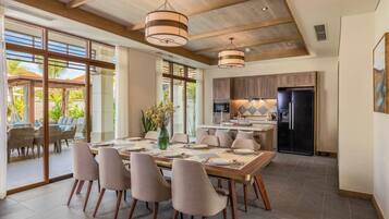 A spacious dining area with a large table set for six, surrounded by modern chairs.