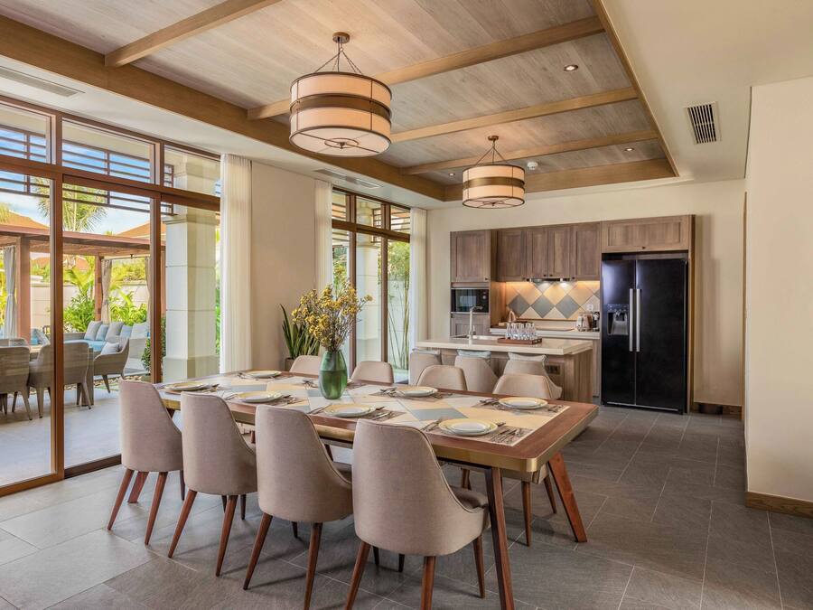 A spacious dining area with a large table set for six, surrounded by modern chairs.