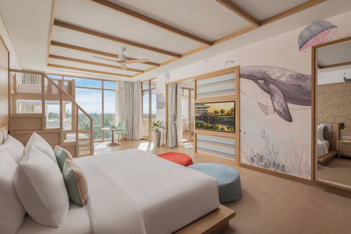 A modern bedroom with a large bed, a staircase, and a mural of a whale.