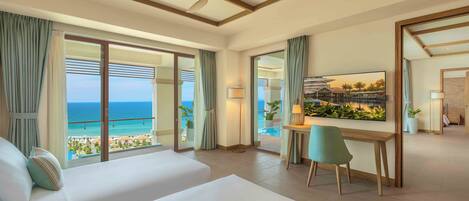 A hotel room with a large bed, a desk, and a view of the ocean.