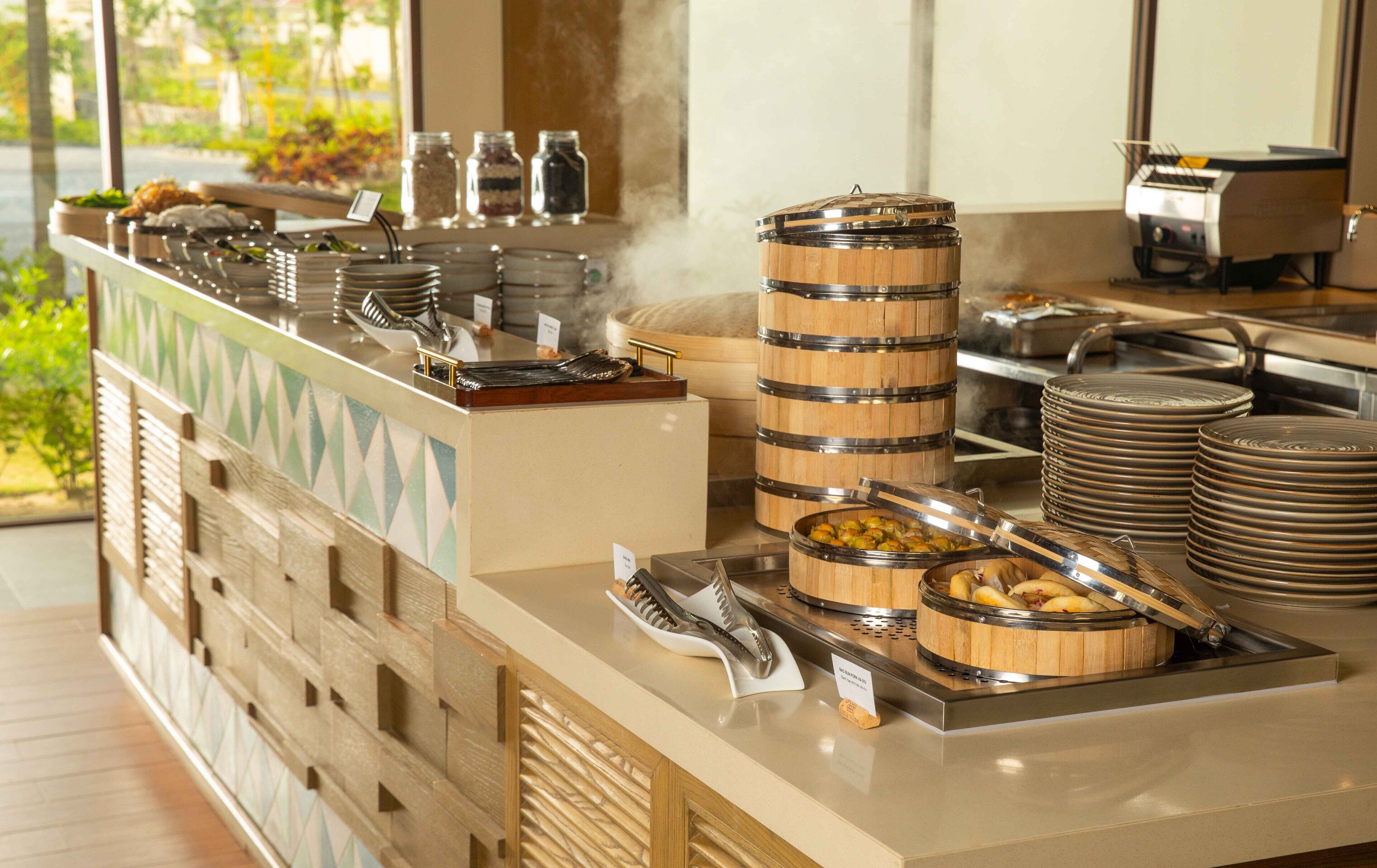 A buffet setup with various food containers and utensils.