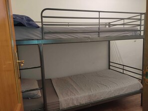 A bunk bed with a lower bunk and a door to the left. - M&m Apartament (Madrid)
