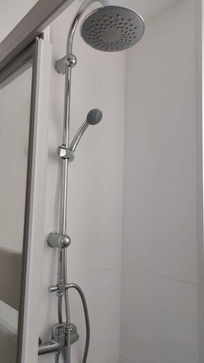 A shower with a handheld showerhead and a wall-mounted rain showerhead. - M&m Apartament (Madrid)