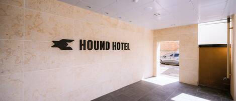 A hotel entrance with a sign reading "HOUND HOTEL" and a tiled floor.