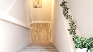 Een wenteltrap met houten vloer die leidt naar een kamer met een houten deur.