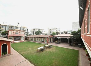 Enjoy al fresco dining and socializing in this charming courtyard with tables, chairs, and lush greenery.