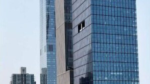 A modern high-rise building with a glass facade and a unique cylindrical structure at the base. - New Luxury apt,Javits Center,NYC (New York)