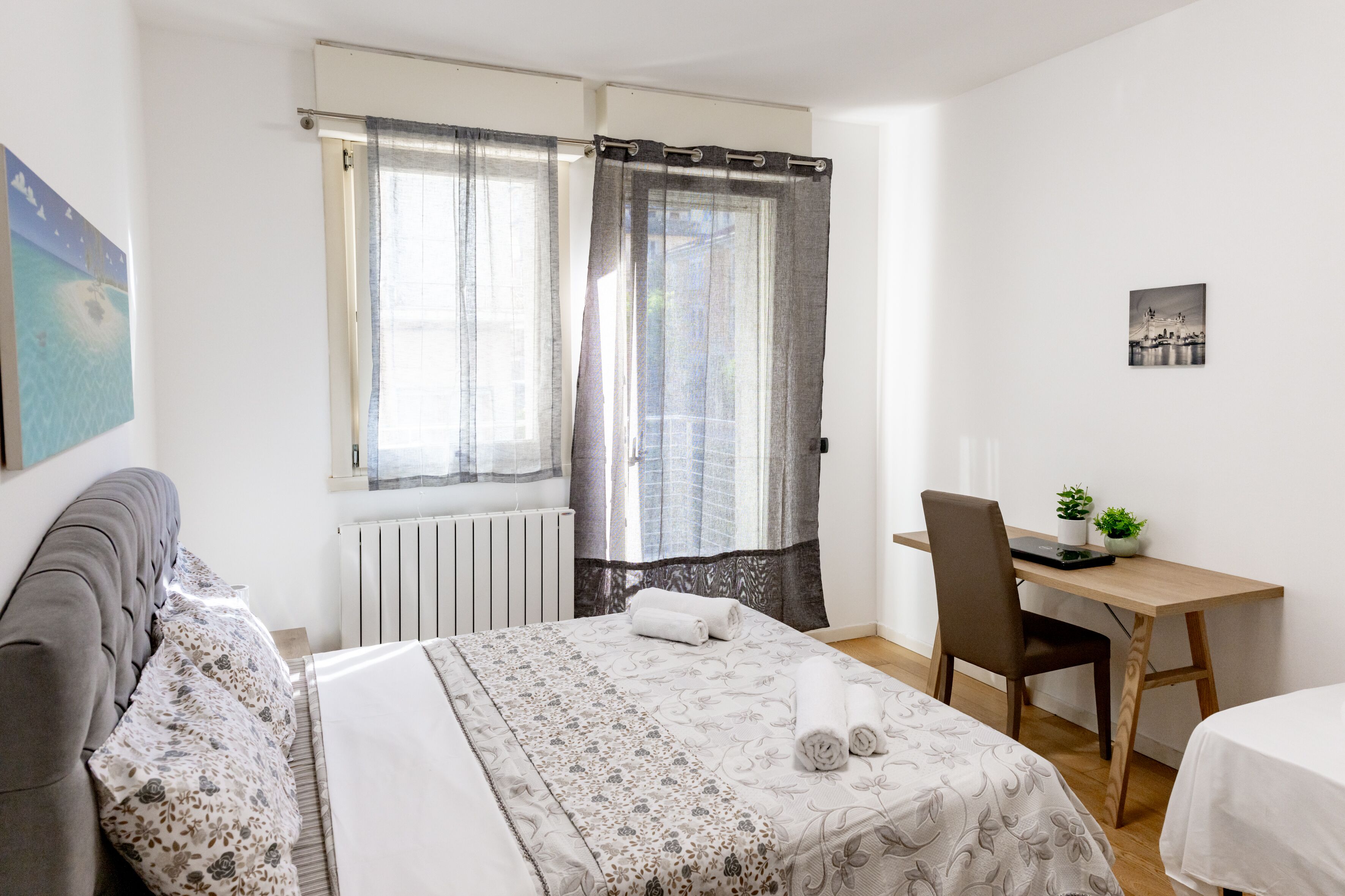 A bedroom with a bed, a desk, and a chair.