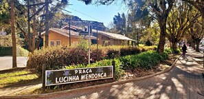 Un panneau indiquant « Praça Lucinha Mendonça », avec un bâtiment en arrière-plan.