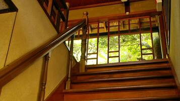 A wooden staircase with a handrail and a window at the top.