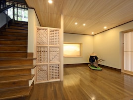 Una escalera de madera conduce a una plataforma con un biombo decorativo y una estatua de oso.