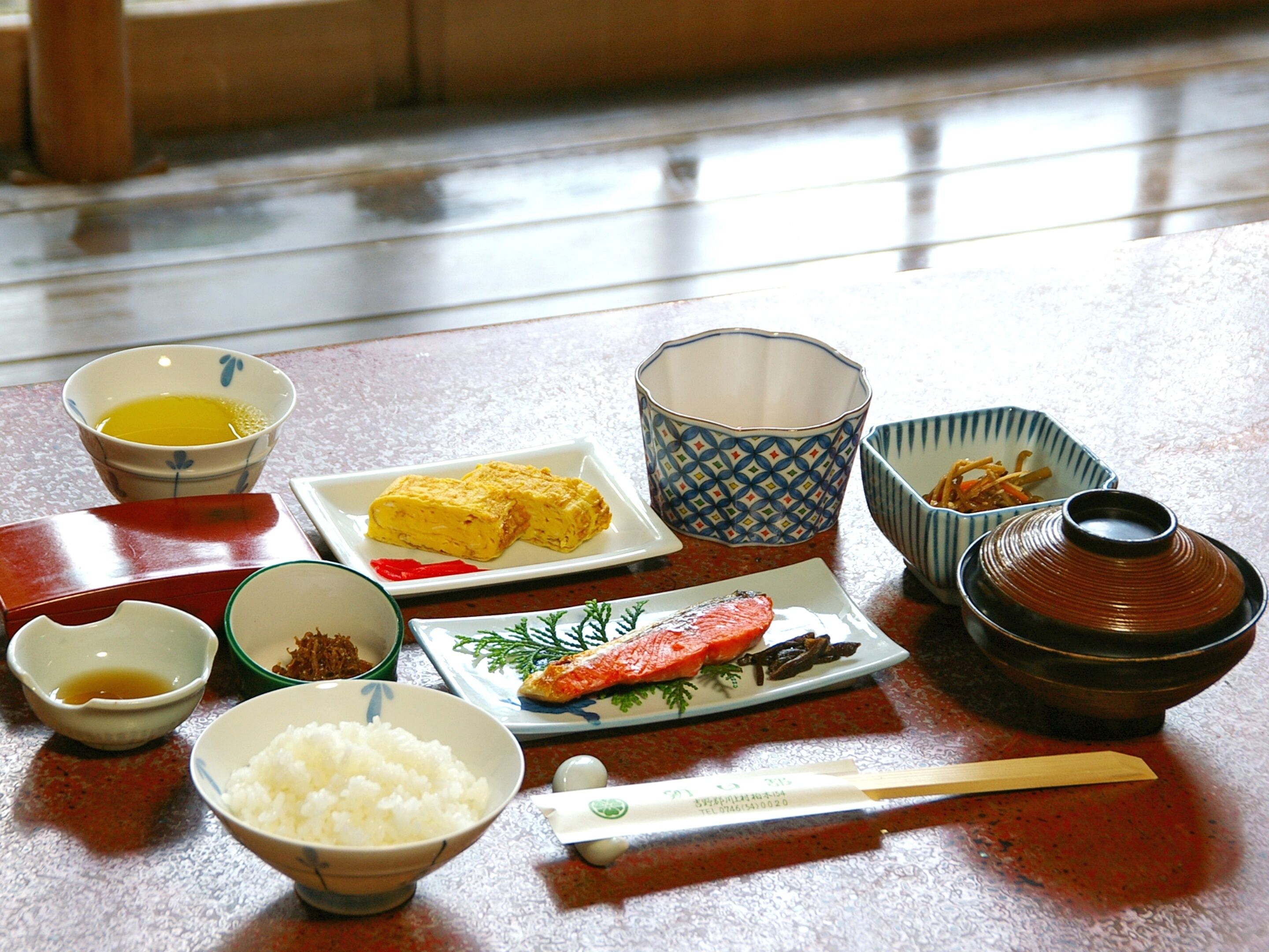 A traditional Japanese meal setup with various dishes and utensils on a table.