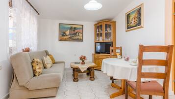 Economy Apartment | Living area | 100-cm flat-screen TV with satellite channels