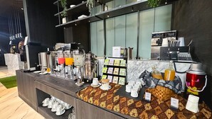 Una estación de café con varios dispensadores, una máquina de café y una variedad de cápsulas de café.