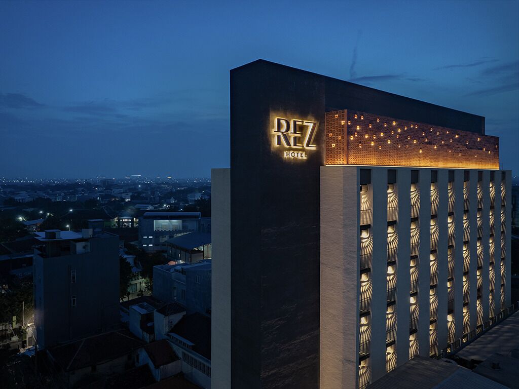 Um hotel com fachada moderna e sinalização iluminada.