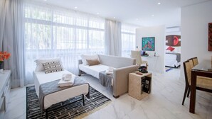 A modern hotel room with a bed, sofa, dining table, and a TV. - Loft moderno com AC na Praça Pôr do Sol (São Paulo)