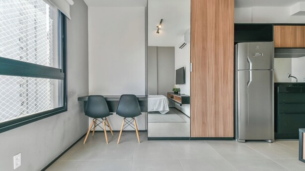 A modern kitchen with a built-in refrigerator, a dining area with two chairs, and a large window providing natural light. - 360 VN Humberto (São Paulo)
