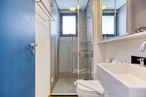 A bathroom with a glass-enclosed shower, a white bathtub, and a large mirror above the sink. - 360 VN Humberto (São Paulo)