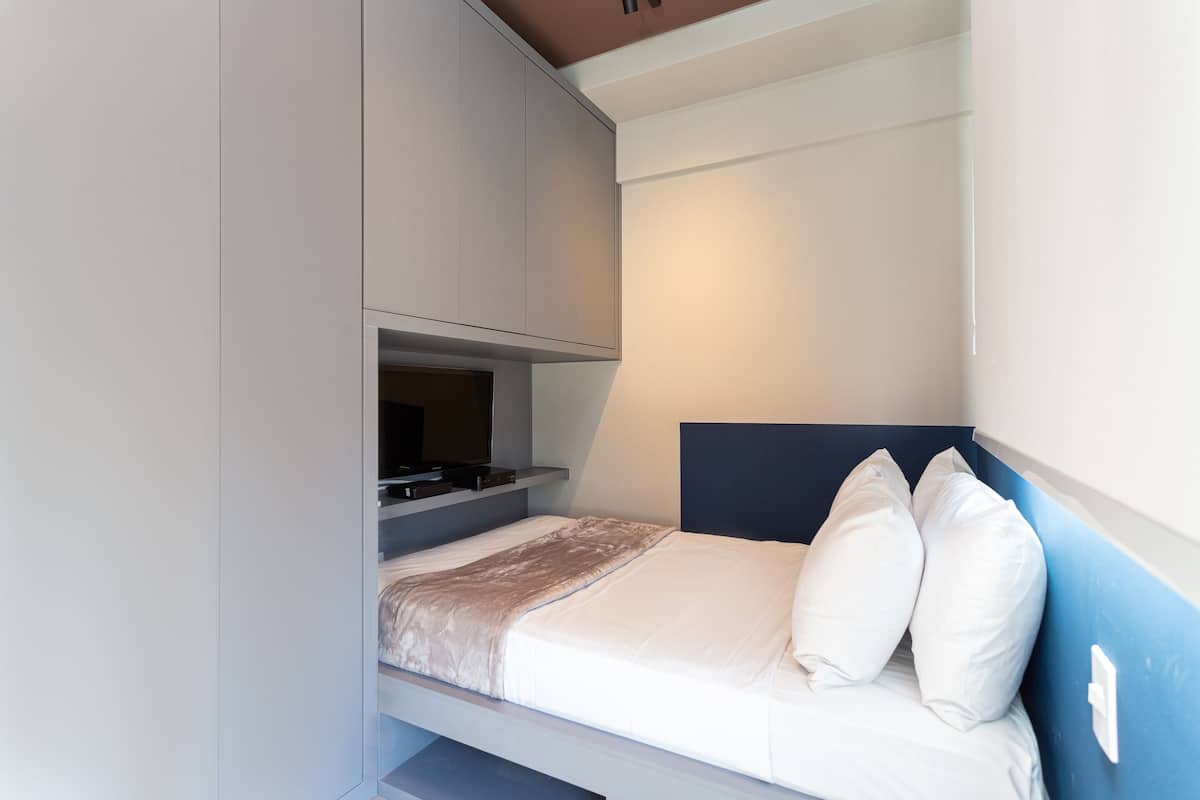 Een knus slaapkamer met een bed, een klein bureau en een televisie.